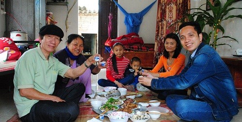 Tác giả (ngoài cùng, bên phải) cùng dự một bữa cơm với một gia đình ở làng phong.
