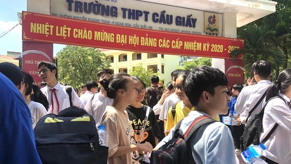 Nhiều em học sinh vui vẻ trao đổi đáp án với nhau ngay tại cổng trường.