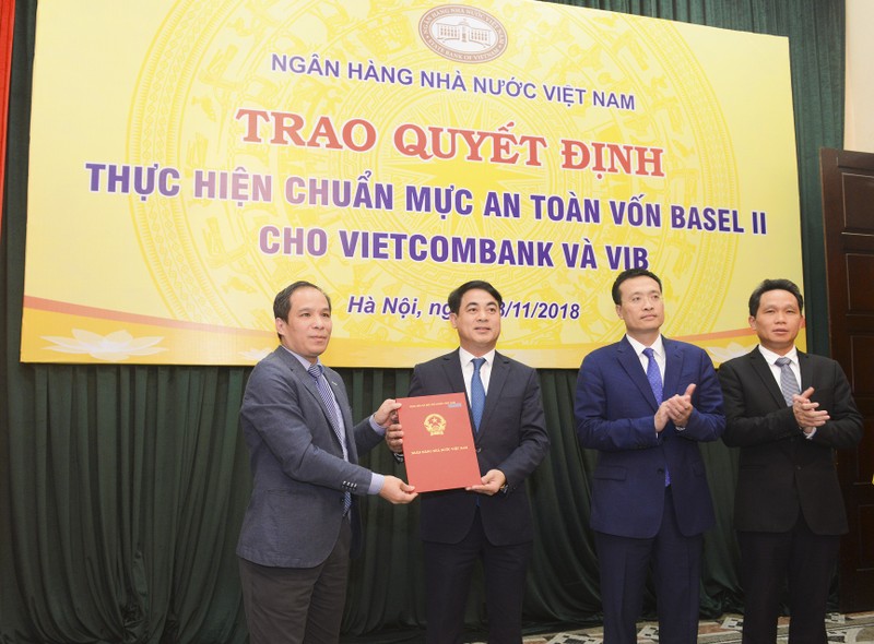Ông Nghiêm Xuân Thành – Chủ tịch HĐQT đại diện Vietcombank nhận quyết định công nhận Vietcombank thực hiện chuẩn mực an toàn vốn Basel II do ông Đoàn Thái Sơn, Phó Thống đốc NHNN Việt Nam trao