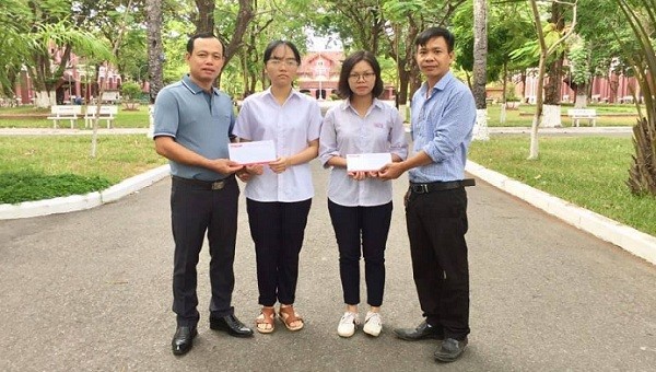 Nhà báo Nguyễn Quang Tám-Trưởng VP đại diện Báo PLVN Khu vực Bình Trị Thiên (Ngoài cùng bên trái) trao tiền hỗ trợ hai em My và Thủy.