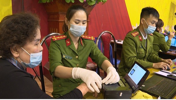 Hướng dẫn người dân lăn vân tay để làm căn cước công dân.