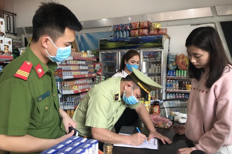 Quản lý thị trường Lạng Sơn tuyên truyền, ký cam kết với hộ kinh doanh. Ảnh: Đình Tuấn.