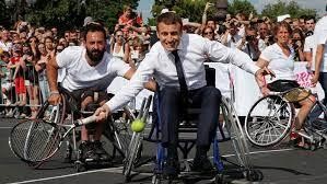 Bức ảnh chụp Tổng thống Pháp Emmanuel Macron ngồi trên xe lăn chơi quần vợt với các vận động viên khuyết tật.