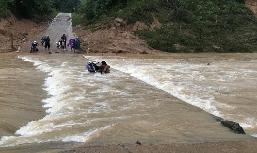 Mặc dù tại cầu tràn nước chảy xiết nhưng 4 thanh niên vẫn liều mình đưa xe máy vượt qua (ảnh Đoàn Nhật Thái)