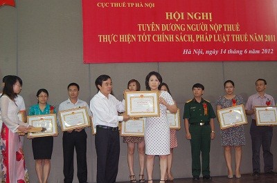Bà Phạm Thị Phú Lợi, đại diện báo Pháp Luật Việt Nam nhận bằng khen của UBND Tp. Hà Nội.