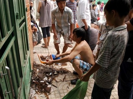 Người dân thu dọn mảnh vụn kính đảm bảo an toàn cho người đi đường di chuyển qua khu vực trên
