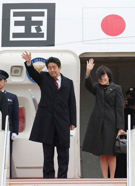 Thủ tướng Nhật Shinzo Abe (giữa) và phu nhân Akie vẫy tay khi rời sân bay quốc tế Tokyo vào sáng nay 16/1 để lên đường tới Hà Nội.