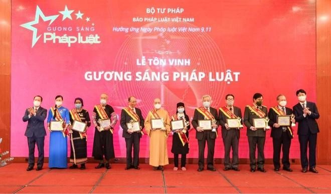 Thứ trưởng Bộ Tư pháp Nguyễn Thanh Tịnh và Tổng Biên tập Báo Pháp luật Việt Nam Đào Văn Hội trao chứng nhận cho các Gương sáng pháp luật trong Lễ tôn vinh.