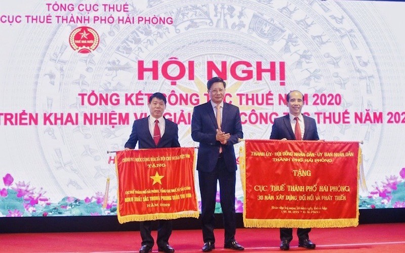Phó chủ tịch Thường trực UBND TP Lê Anh Quân trao cờ của Chính phủ tặng Cục Thuế Hải Phòng.
