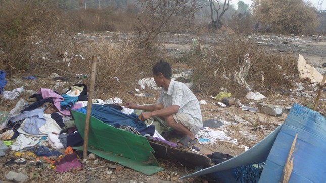 Ông Hoành đang tìm những chiếc khuya  áo trong đống vải cũ còn sót lại.