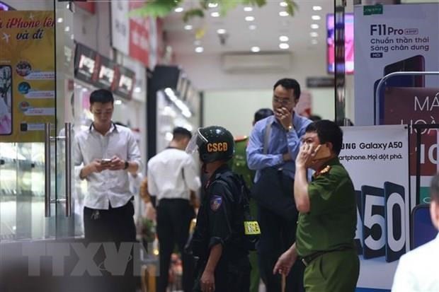 Cảnh sát kiểm tra, khám xét tại cửa hàng điện thoại Nhật Cường mobile ở 33 Lý Quốc Sư, Hà Nội. (Ảnh: TTXVN)