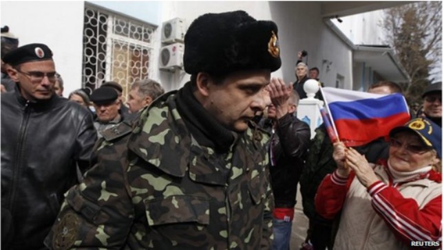 Một binh lính Ukraine được những người ủng hộ Nga cổ vũ khi rời khỏi căn cứ ở Sevastopol