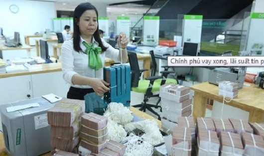 Trước mắt, nhu cầu vay vốn của Chính phủ bằng trái phiếu như trên tạm thời bớt chia sẻ nguồn vốn trên thị trường, cung vốn của các ngân hàng thương mại có thể tiếp tục dư thừa rõ hơn - Ảnh: Quang Phúc