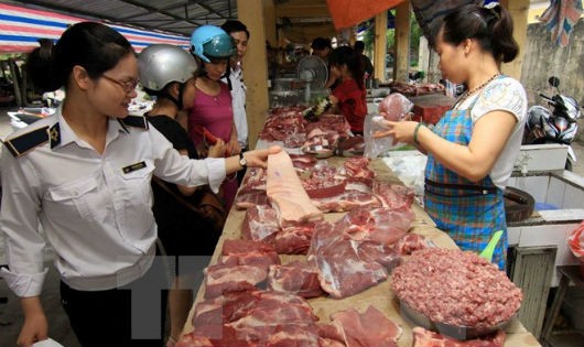 Nhân viên thú y kiểm tra hộ kinh doanh thịt lợn tại chợ. (Ảnh: Vũ Sinh/TTXVN)