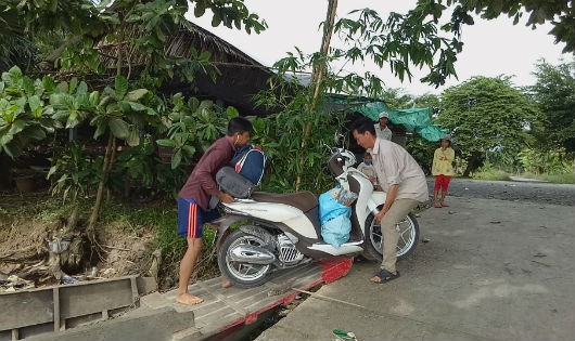 Để qua sông người dân phải vất vả khiêng những phương tiện xuống đò