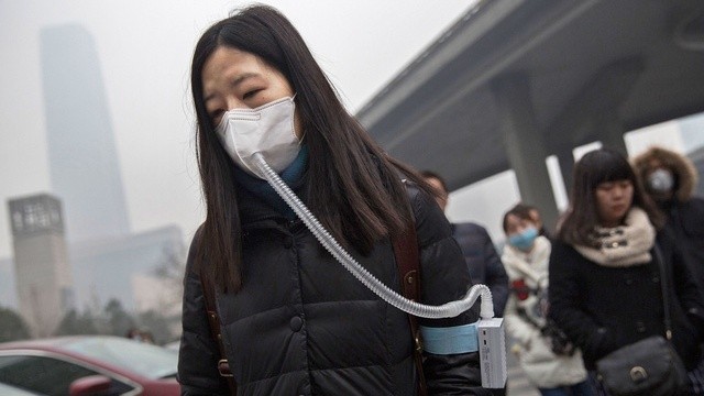 Bức ảnh về người phụ nữ sử dụng thiết bị lọc không khí tại Bắc Kinh là ví dụ về mức độ ô nhiễm tại thành phố này. (Nguồn: Internet)