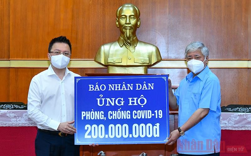 Tổng Biên tập Báo Nhân Dân Lê Quốc Minh trao số tiền ủng hộ phòng, chống dịch Covid-19 cho Chủ tịch Ủy ban TƯ MTTQ Việt Nam Đỗ Văn Chiến. Ảnh: Duy Linh