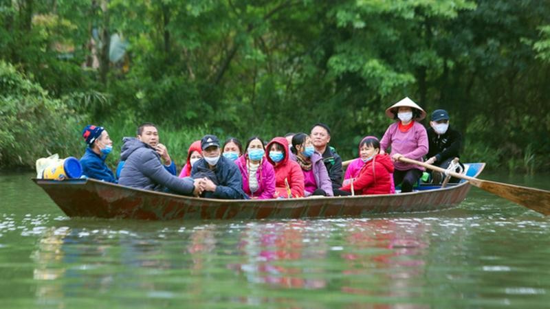 Du khách tháo khẩu trang và không mặc áo phao khi đi đò ở chùa Hương. Ảnh Đông Hồ