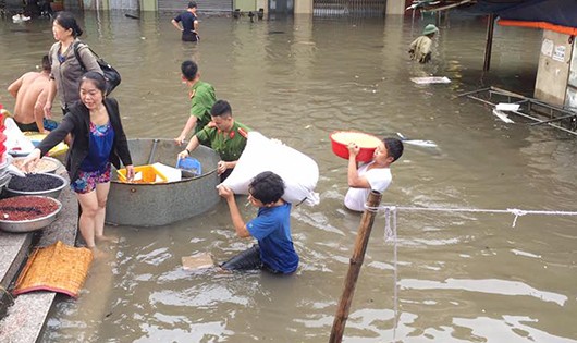 Tiểu thương bì bõm lội nước vớt vát lại tài sản ngập trong nước.