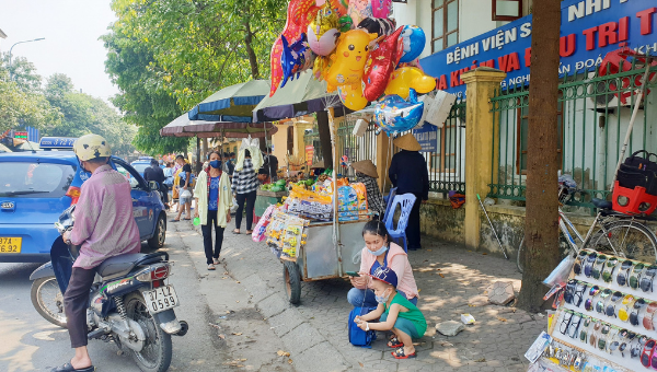 Vỉa hè bị chiếm dụng làm nơi buôn bán khiến người đi bộ phải đi dưới lòng đường.