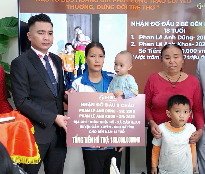 Đại diện Cty CP ĐT&TM Hoàng Gia Phát trao biểu trưng nhận nuôi đỡ đầu hai cháu bé tại Hà Tĩnh đến năm 18 tuổi.