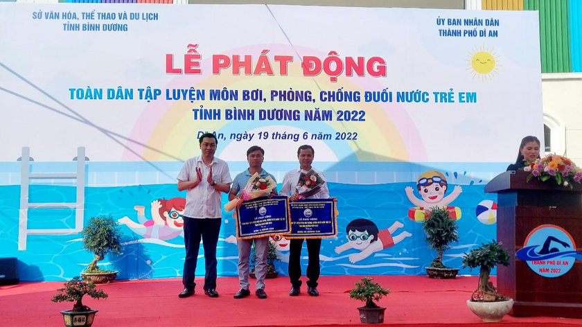 Ông Cao Văn Chóng – Phó Giám đốc Sở VHTTDL Bình Dương trao cờ và hoa cho đơn vị đăng cai (Khu vui chơi giải trí Hoàng Hùng; Phòng Văn hóa và Thông tin thành phố Dĩ An – tỉnh Bình Dương) 