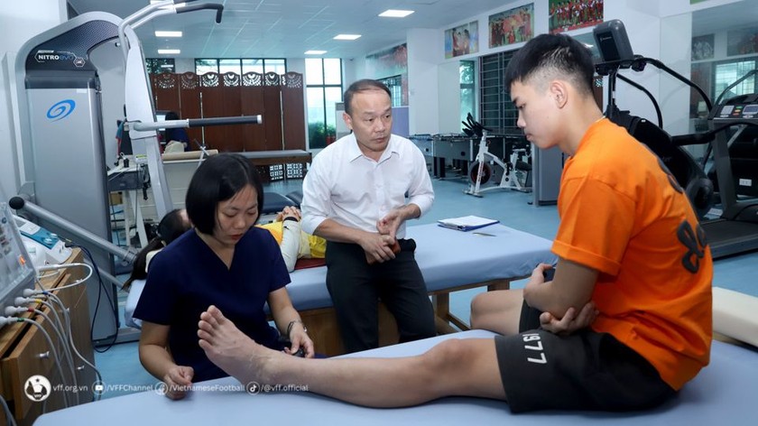 BS Nguyễn Văn Phú – Trưởng phòng Y học thể thao VFF – kiểm tra tình trạng chấn thương cổ chân của Đình Bắc. Ảnh VFF 