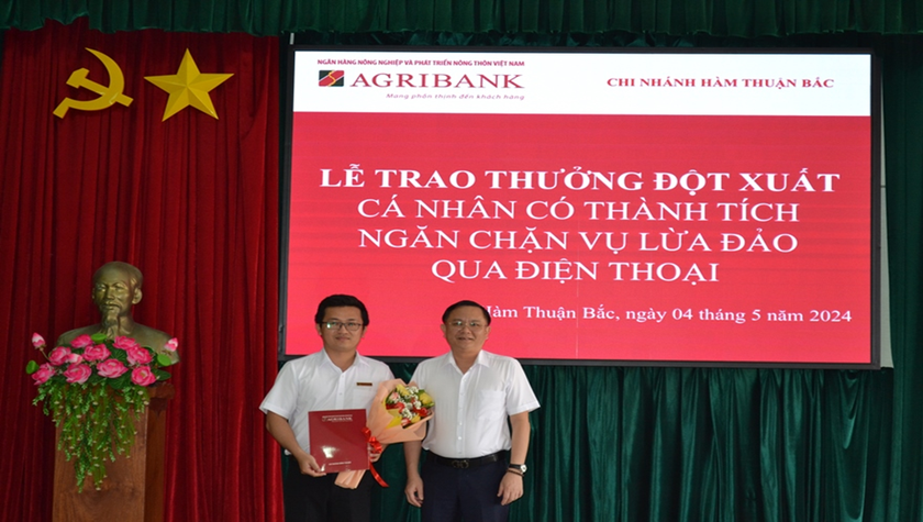 Ông Nguyễn Hữu Câu (bên phải) - Giám đốc Agribank chi nhánh tỉnh Bình Thuận - trao khen thưởng đột xuất cho cán bộ tín dụng Nguyễn Minh Khanh.