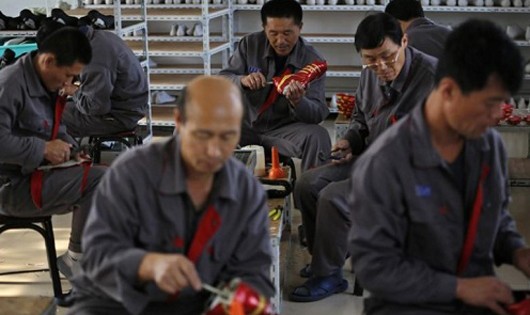 Công nhân Triều Tiên làm giày đá bóng trong một xưởng nhỏ tại một ngôi làng ở rìa thành phố Đan Đông, tỉnh Liêu Ninh, Trung Quốc hồi tháng 10/2012. Ảnh: Reuters.