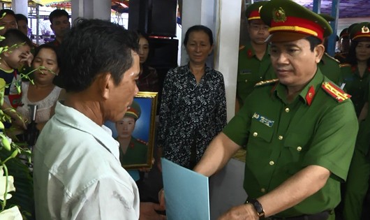 Đại diện Cảnh sát PC&CC TP HCM trao quyết định thăng cấp bậc hàm trước niên hạn cho gia đình đồng chí Phạm Phi Long. Ảnh: Cổng thông tin Cảnh sát PC&CC TP HCM.