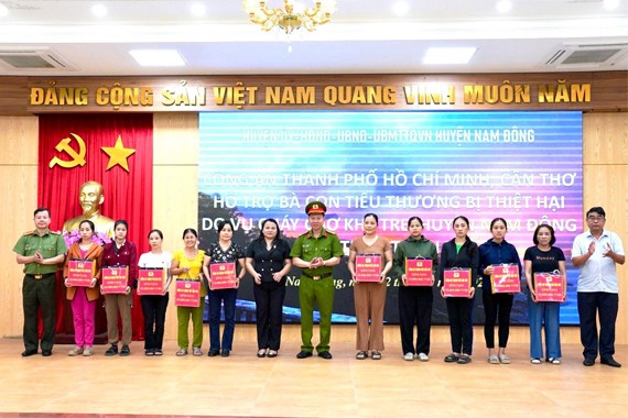 Đại tá Trần Hoàng Độ (giữa) và Đại tá Nguyễn Hữu Thiên (bên trái ngoài cùng) trao quà cho các tiểu thương trong vụ cháy chợ Khe Tre.