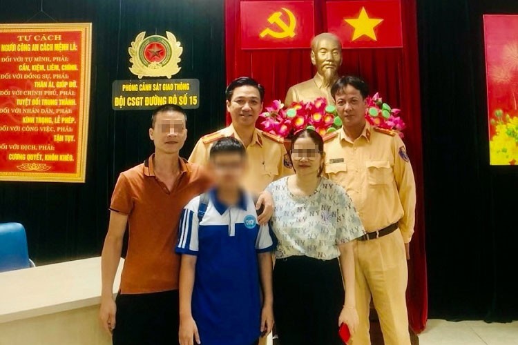 Trung tá Tạ Ngọc Khánh, Đội Trưởng, cùng Tổ công tác Đội CSGT đường bộ số 15, bàn giao L. cho người thân của cháu. (Ảnh: CA Hà Nội).