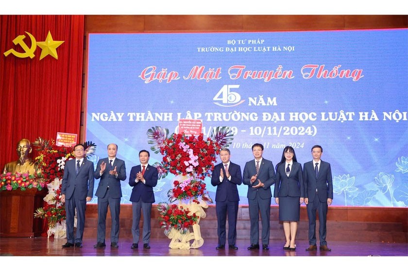 Bộ trưởng Bộ Tư pháp Nguyễn Hải Ninh tặng hoa lãnh đạo Hội đồng Trường và Ban Giám hiệu Nhà trường.