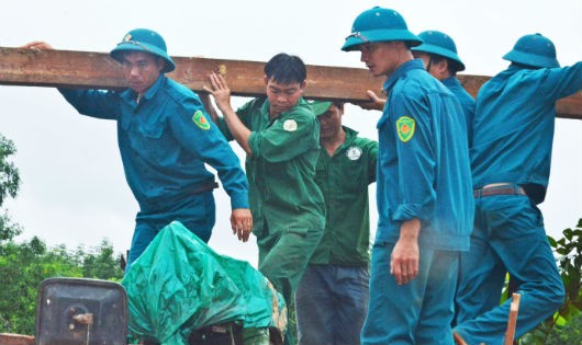 Các chiến sĩ công an, bộ đội không quản khó khăn giúp người dân thu dọn đồ đạc, dựng lại nhà cửa sau cơn lũ.