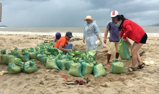 Người dân Nha Trang xúc cát về chèn mái nhà.