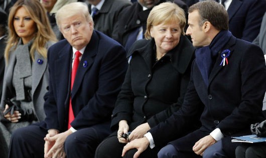 Ông Trump (thứ ba từ phải sang) ngồi dự lễ kỷ niệm trong khi Thủ tướng Đức Merkel và Tổng thống Pháp Macron (phải) trao đổi cùng nhau.
