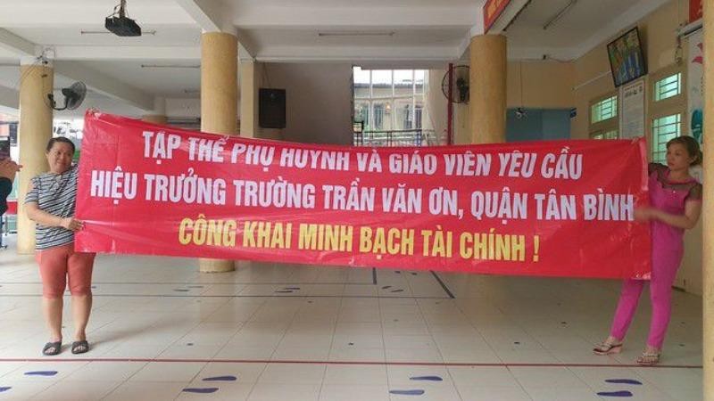 Phụ huynh Trường tiểu học Trần Văn Ơn căng băng rôn yêu cầu hiệu trưởng trường này phải công khai, minh bạch tài chính.