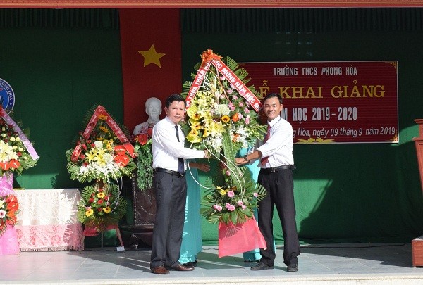 Giám đốc Sở GD&ĐT tỉnh TT- Huế Nguyễn Tân (bên trái) tặng hoa chúc mừng thầy và trò Trường THCS Phong Hòa nhân dịp năm học mới 