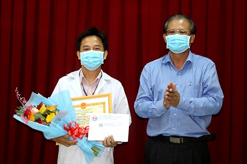Ông Nguyễn Lâm Thái Thuận - GĐ Sở Y tế Đồng Tháp trao Giấy khen và tặng hoa cho Bác sỹ Lê Ngọc Lâm (ảnh Văn Khương)