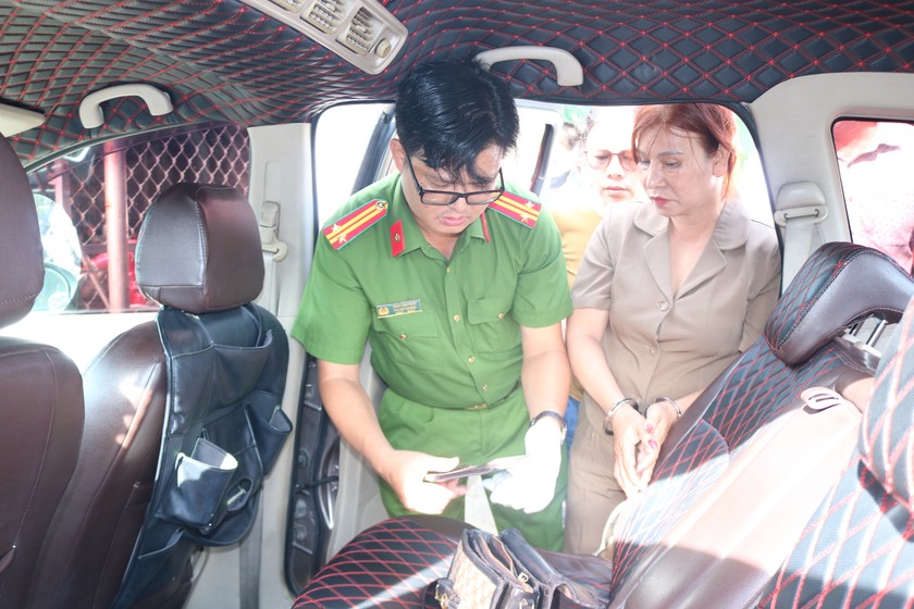 Cơ quan chức năng khám xét túi đồ trên người và xe ô tô của Nguyễn Thị Thúy Vân (phải).