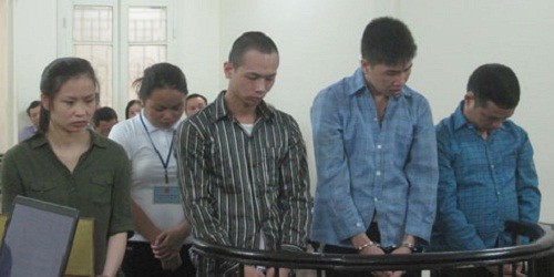Bị cáo Thu (áo nâu) và bị cáo Huy (thứ 2 từ phải qua trái) cùng đồng bọn tại tòa.