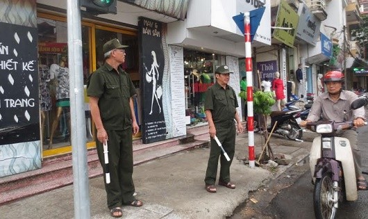 Ông Hùng (bên trái) cùng thành viên trong tổ tuần tra chốt tại các điểm giao thông.