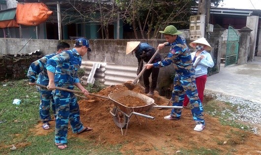 Giúp dân thu gom rác thải bên bờ sông Lam.