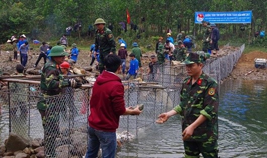 Bộ đội, trí thức trẻ tình nguyện Lâm trường 103 phối hợp đắp đập, đưa nước về bản Tình Á.