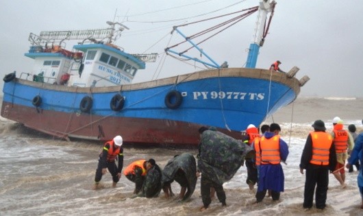 Các đơn vị quân đội tham gia kéo tàu cá bị nạn vào bờ.