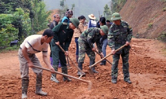 Cán bộ, chiến sĩ Đồn Biên phòng Bảo Lâm giúp dân làm đường giao thông nông thôn. 
(Hình:baolangson.vn)