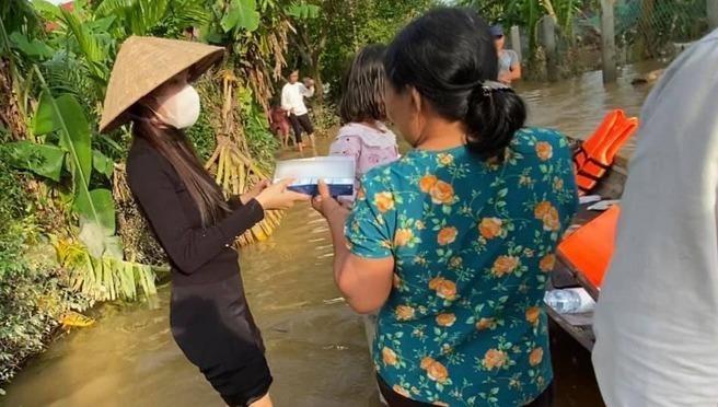 Thủy Tiên (áo đen) đến vùng bị ngập ở Huế để trao quà cho người dân.