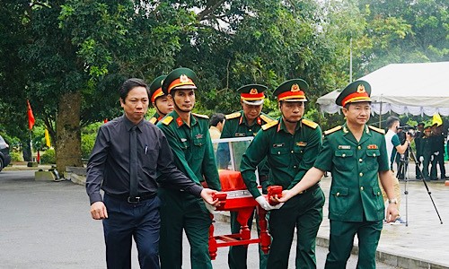 Các đại biểu cùng cán bộ, chiến sĩ lực lượng vũ trang đưa hài cốt liệt sĩ đến nơi an táng.