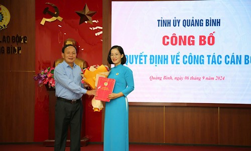 Ông Trần Hải Châu - Phó Bí thư Thường trực Tỉnh ủy, Chủ tịch HĐND tỉnh Quảng Bình trao quyết định và tặng hoa chúc mừng bà Đinh Thị Ngọc Lan.