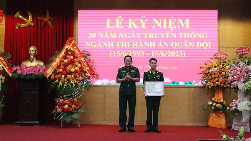 Thứ trưởng Bộ Quốc phòng, Thượng tướng Võ Minh Lương (bên trái) trao Bằng khen của Bộ trưởng Bộ Quốc phòng cho Cục Thi hành án.